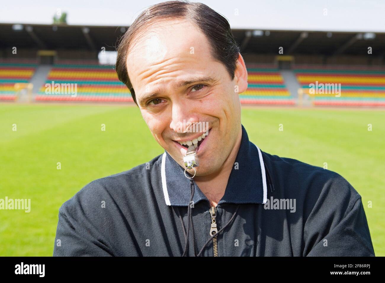 Portrait lächelnder, selbstbewusster Fußballtrainer mit Pfeife auf dem Feld Stockfoto