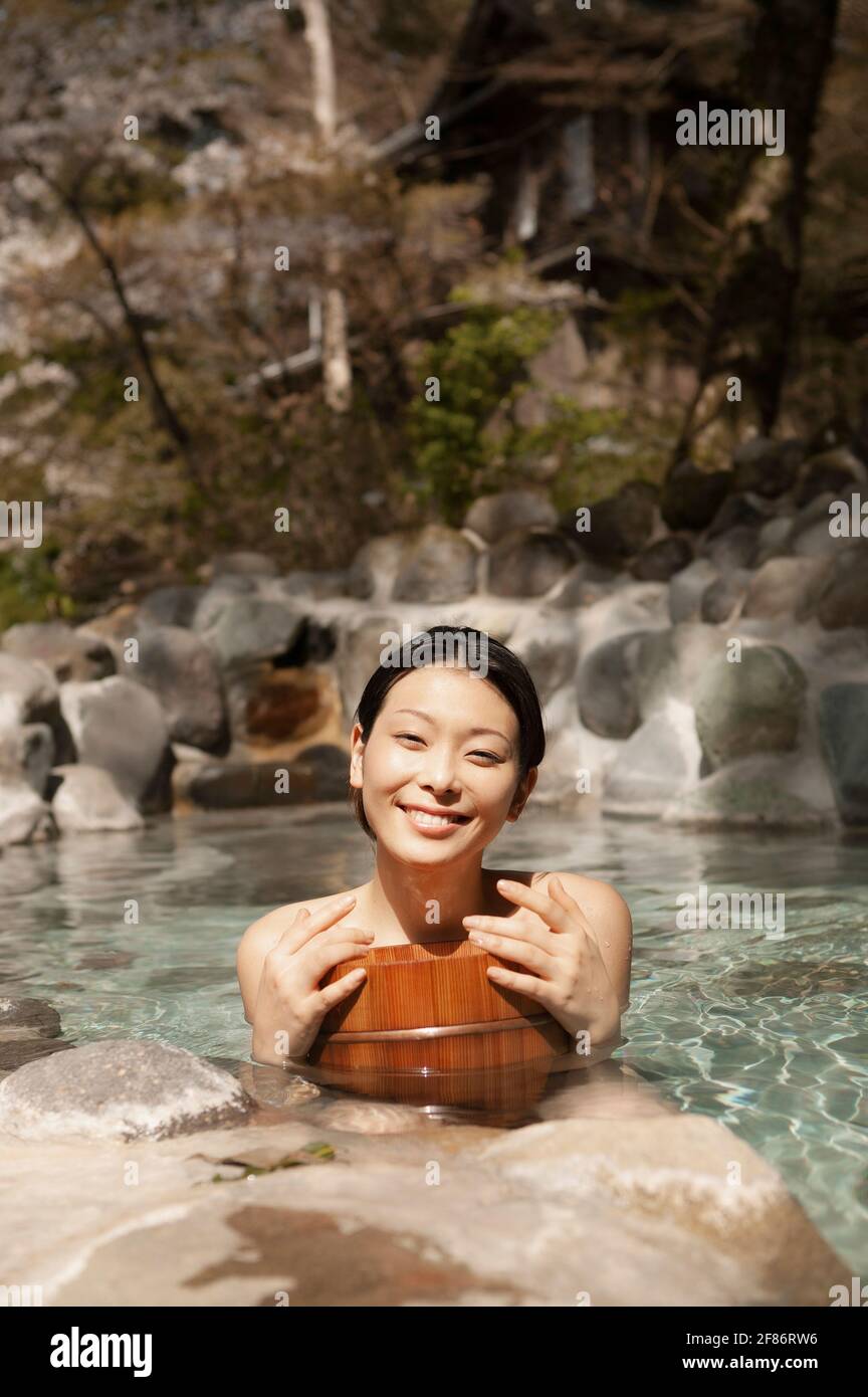 Porträt glücklich schöne junge Frau im sonnigen Pool in Onsen Stockfoto