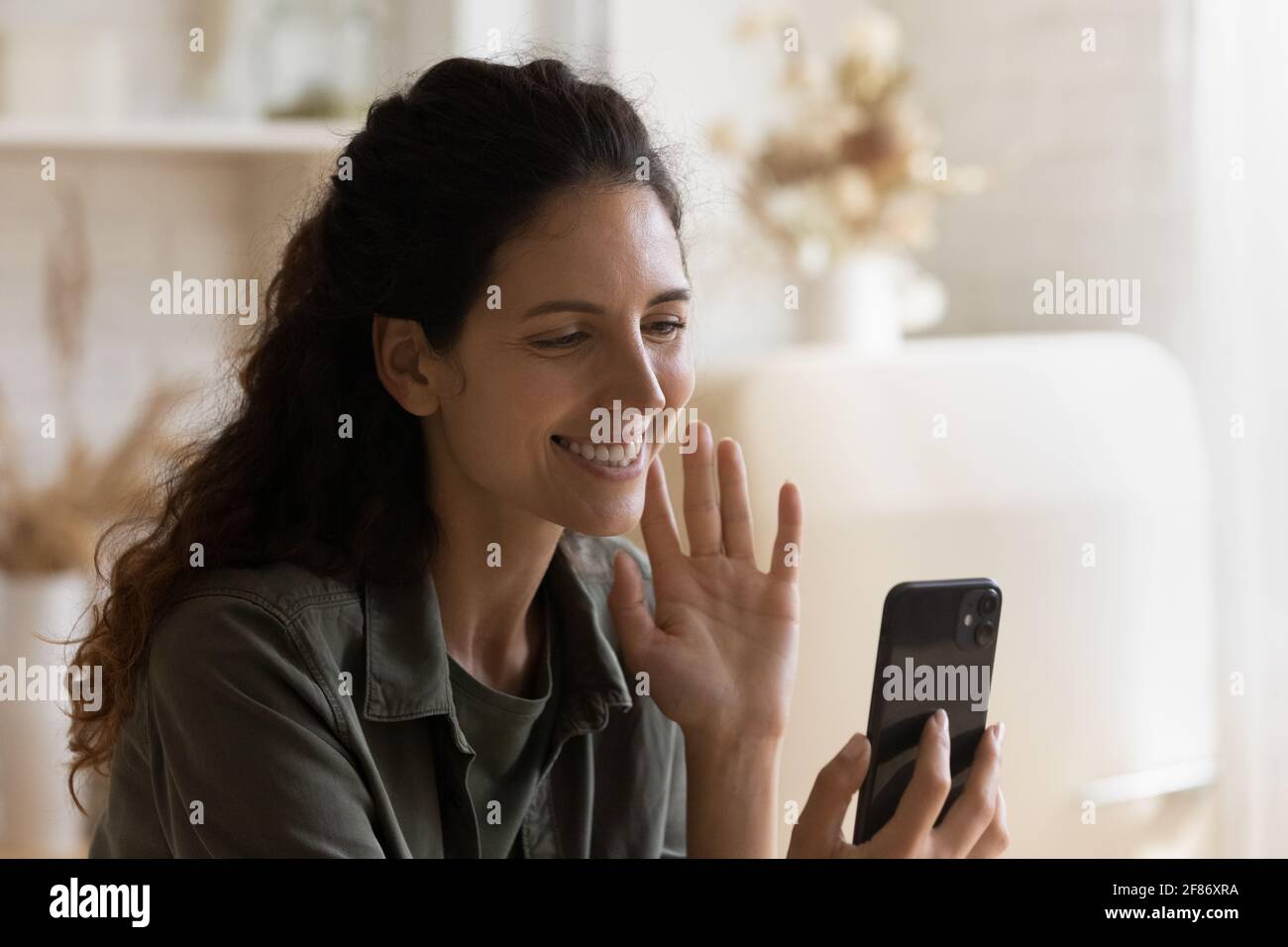 Nahaufnahme lächelnde Frau, die Hand auf das Smartphone schwenkt, Videoanruf Stockfoto