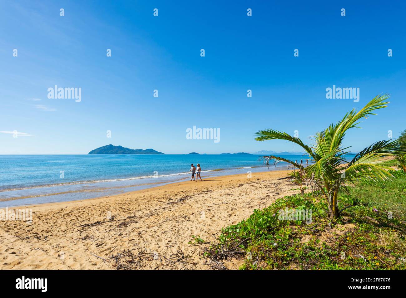Zwei Personen, die am Strand von Wongaling, Mission Beach, Queensland, QLD, Australien, spazieren gehen Stockfoto