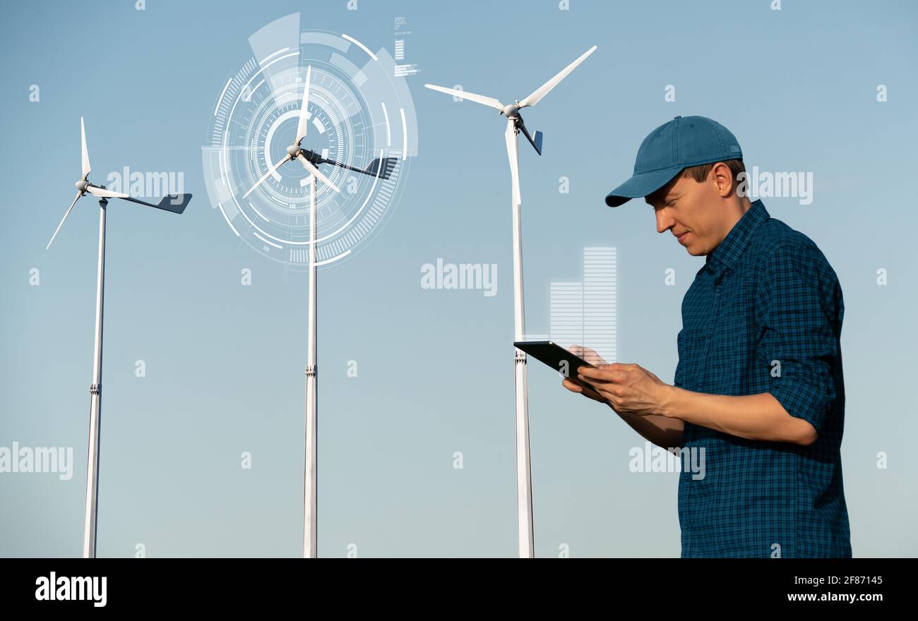 Ingenieur mit Tablet-Computer auf einem Hintergrund von Windenergieanlagen Stockfoto