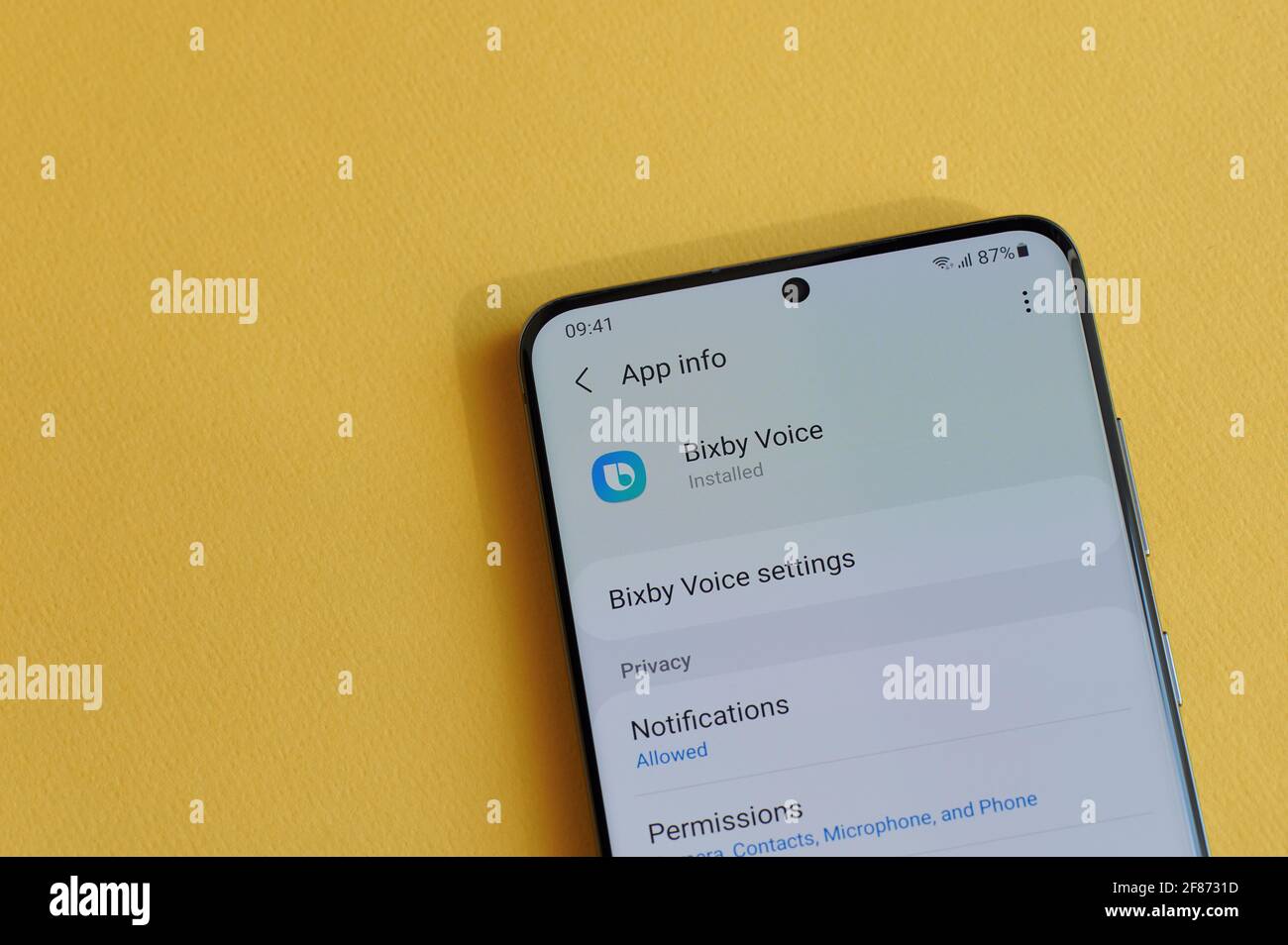 New york, USA - 12. April 2021: Änderung der Privatsphäre-Einstellung in der Bixby Assistant App auf dem Smartphone-Bildschirm auf gelbem Hintergrund Stockfoto