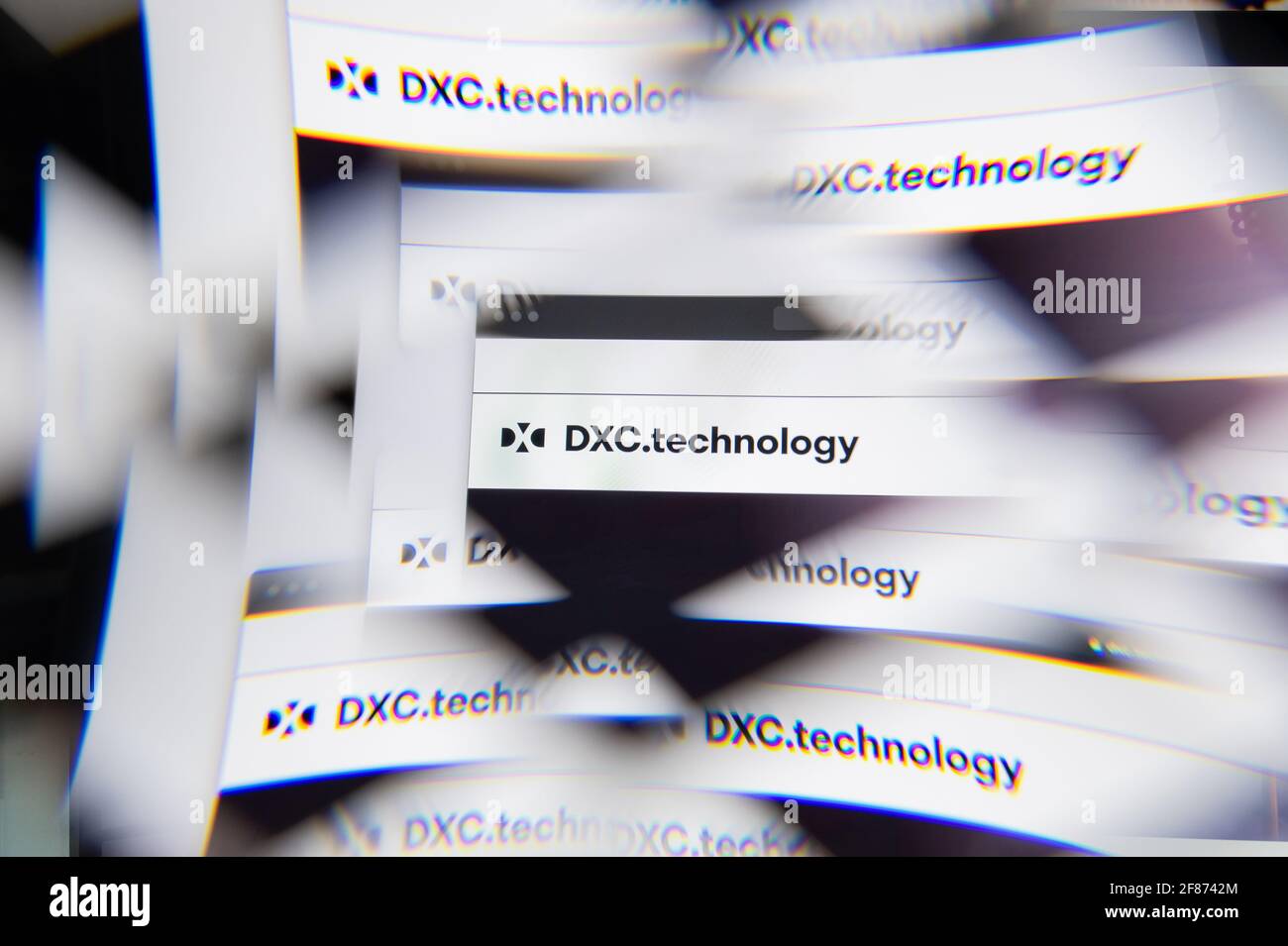 Mailand, Italien - 10. APRIL 2021: Logo der DXC-Technologie auf dem Laptop-Bildschirm, das durch ein optisches Prisma gesehen wird. Illustratives redaktionelles Bild von DXC Technology We Stockfoto