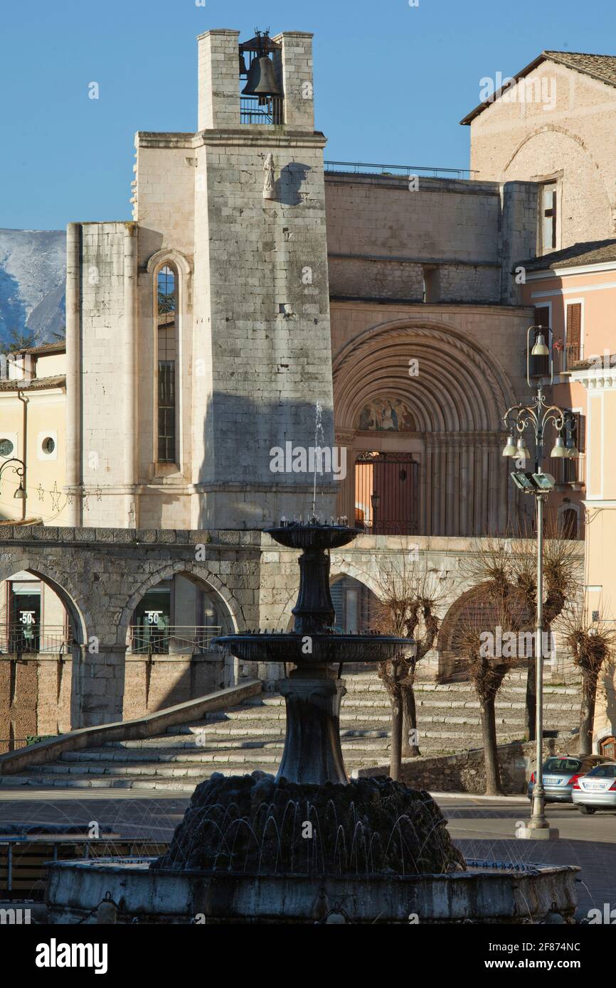 Glockenturm und Seiteneingang von San Francesco della Scarpa in Sulmona. Im Vordergrund der monumentale Brunnen und das mittelalterliche Aquädukt. Abruzzen Stockfoto