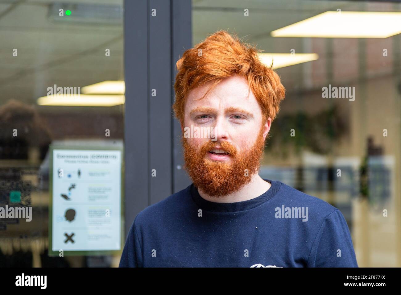 Halesowen, West Midlands, Großbritannien. April 2021. Firmenchef Rhys Barrett, 27, geht zu seinem Barbier in Halesowen, West Midlands, um einen willkommenen Haarschnitt und Bartschnitt zu erhalten, während sich die Barbiere nach der Lockerung der Covid-Beschränkungen heute öffnen. Kredit: Peter Lopeman/Alamy Live Nachrichten Stockfoto