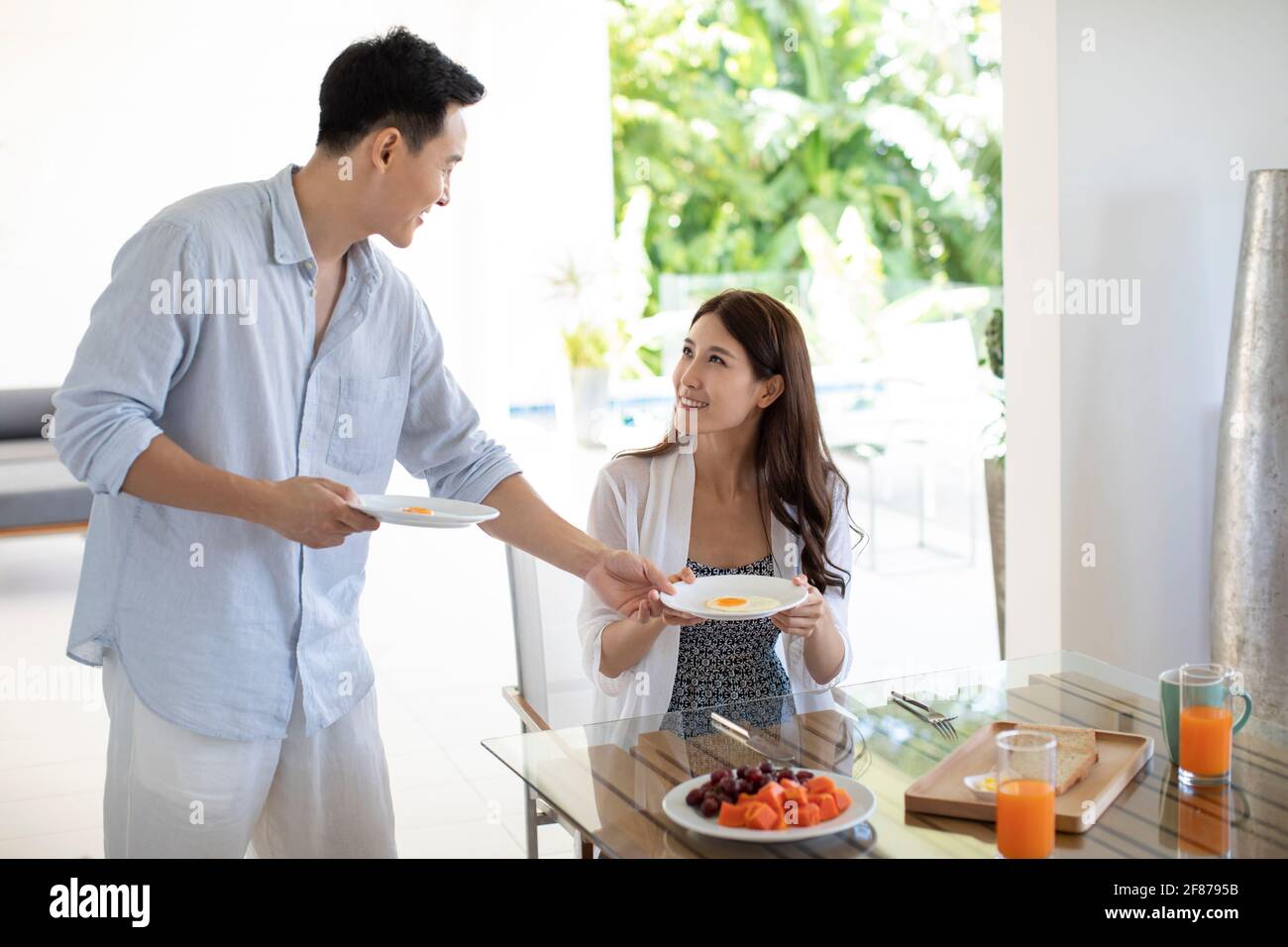 Ein glückliches junges Paar, das im Hotelzimmer gefrühstückt hat Stockfoto