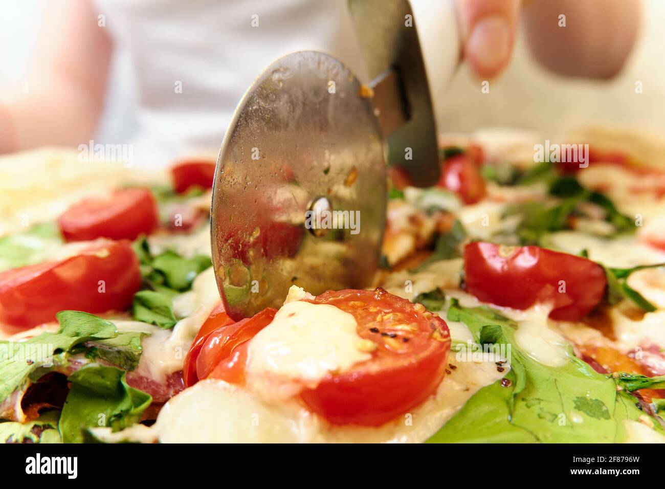 Pizza mit Käse, Tomaten, Spinat und Räucherwurst Stockfoto