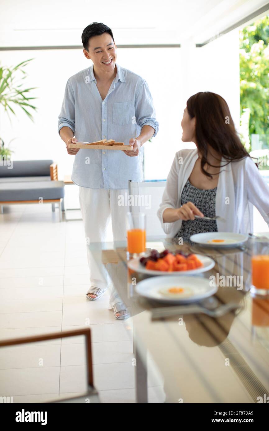 Ein glückliches junges Paar, das im Hotelzimmer gefrühstückt hat Stockfoto