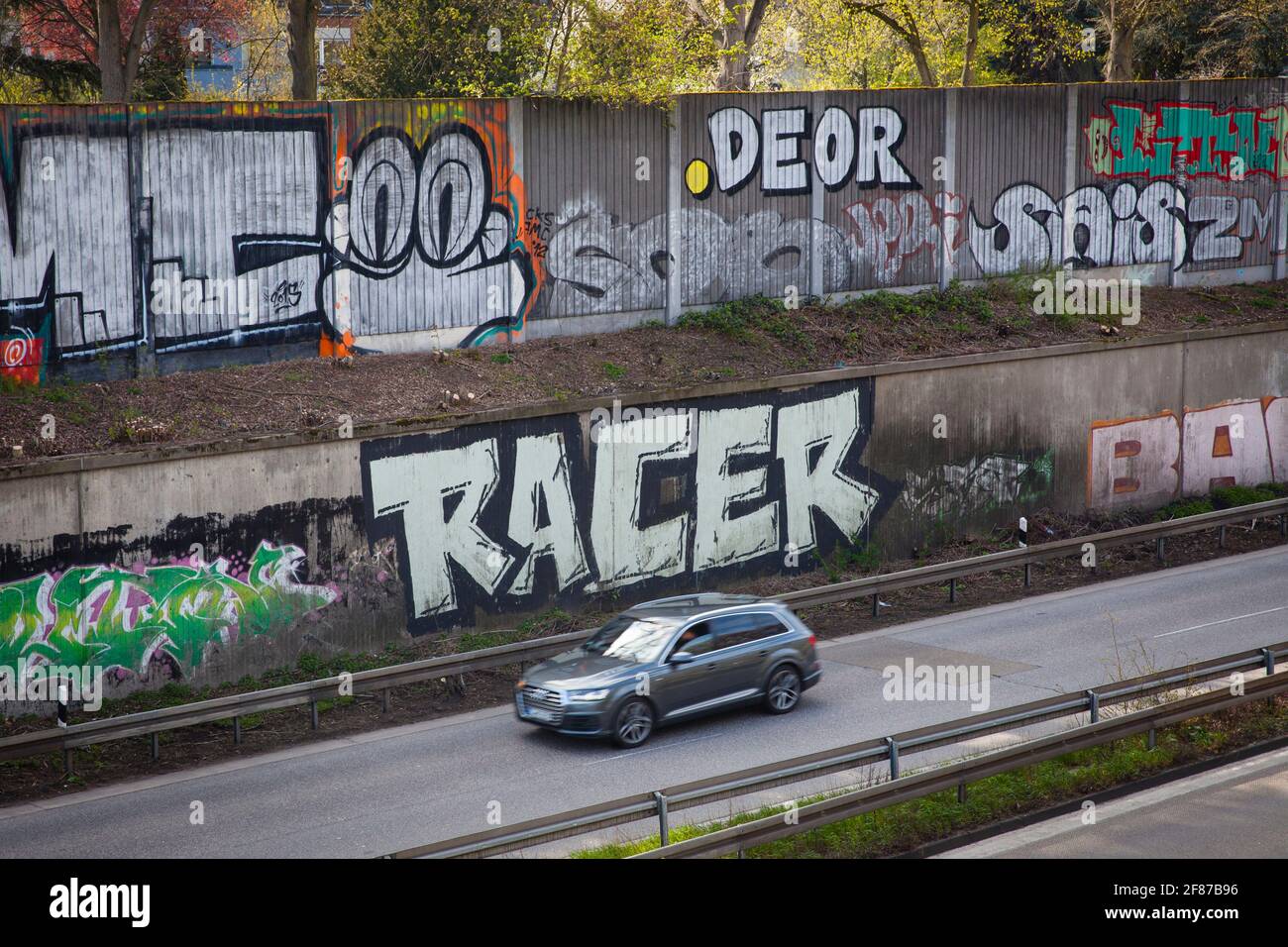 Graffiti auf Schallmauer der Autobahn A 57 im Bezirk Neu-Ehrenfeld, Köln, Deutschland. Graffitis an der Schallschutzwand der Autobahn A 57 Stockfoto
