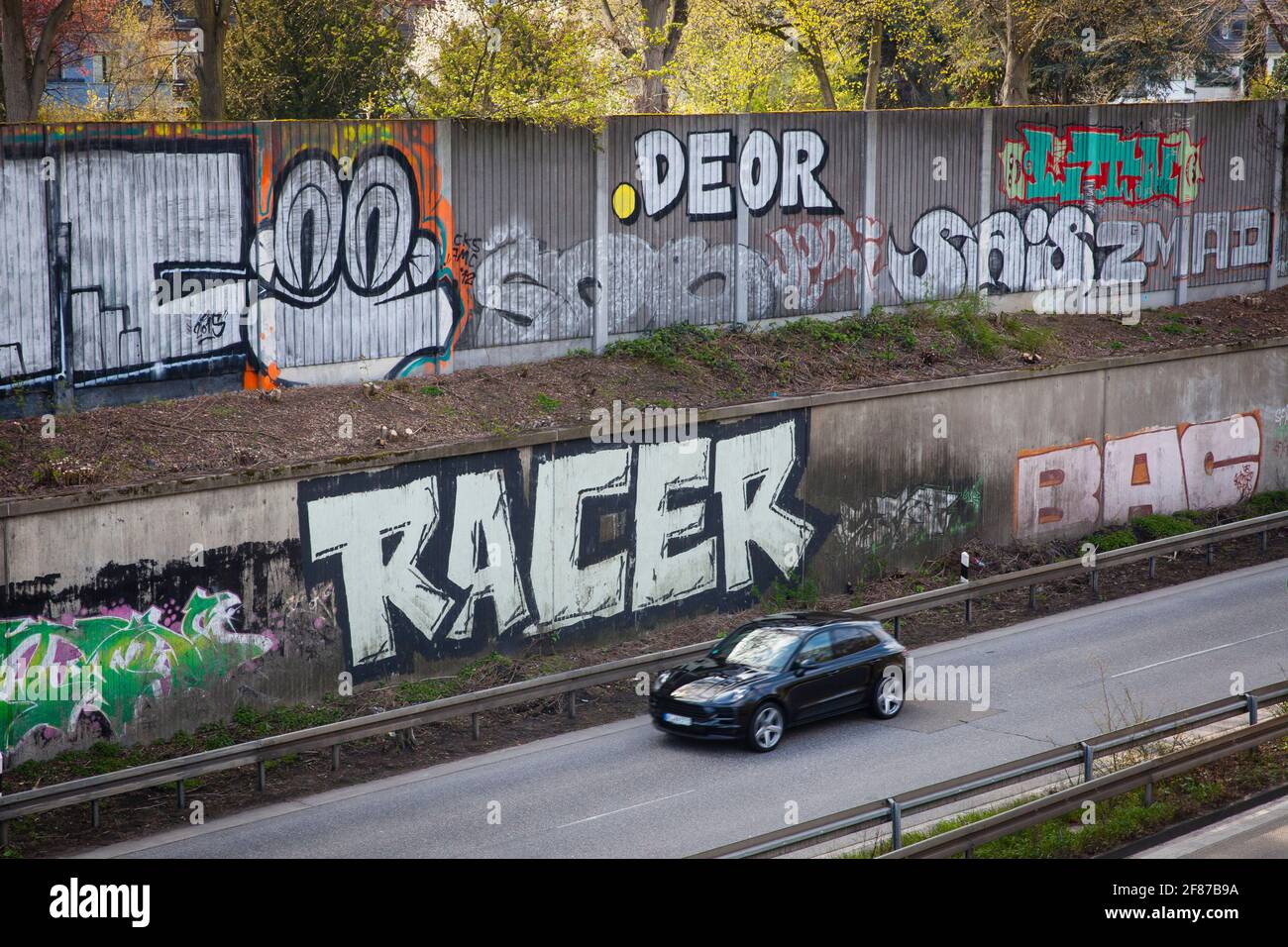 Graffiti auf Schallmauer der Autobahn A 57 im Bezirk Neu-Ehrenfeld, Köln, Deutschland. Graffitis an der Schallschutzwand der Autobahn A 57 Stockfoto