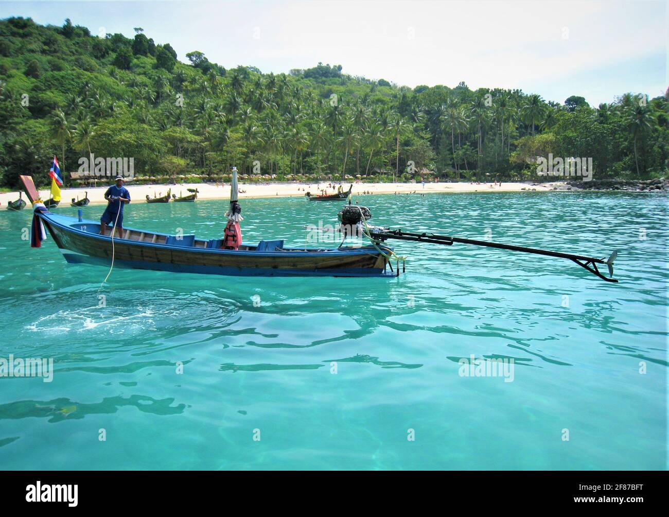 Wunderschöne Langschwanz-Boote in den blauen Gewässern einer Bucht von Phuket in Thailand bereit, mit Touristen zu gehen. Stockfoto