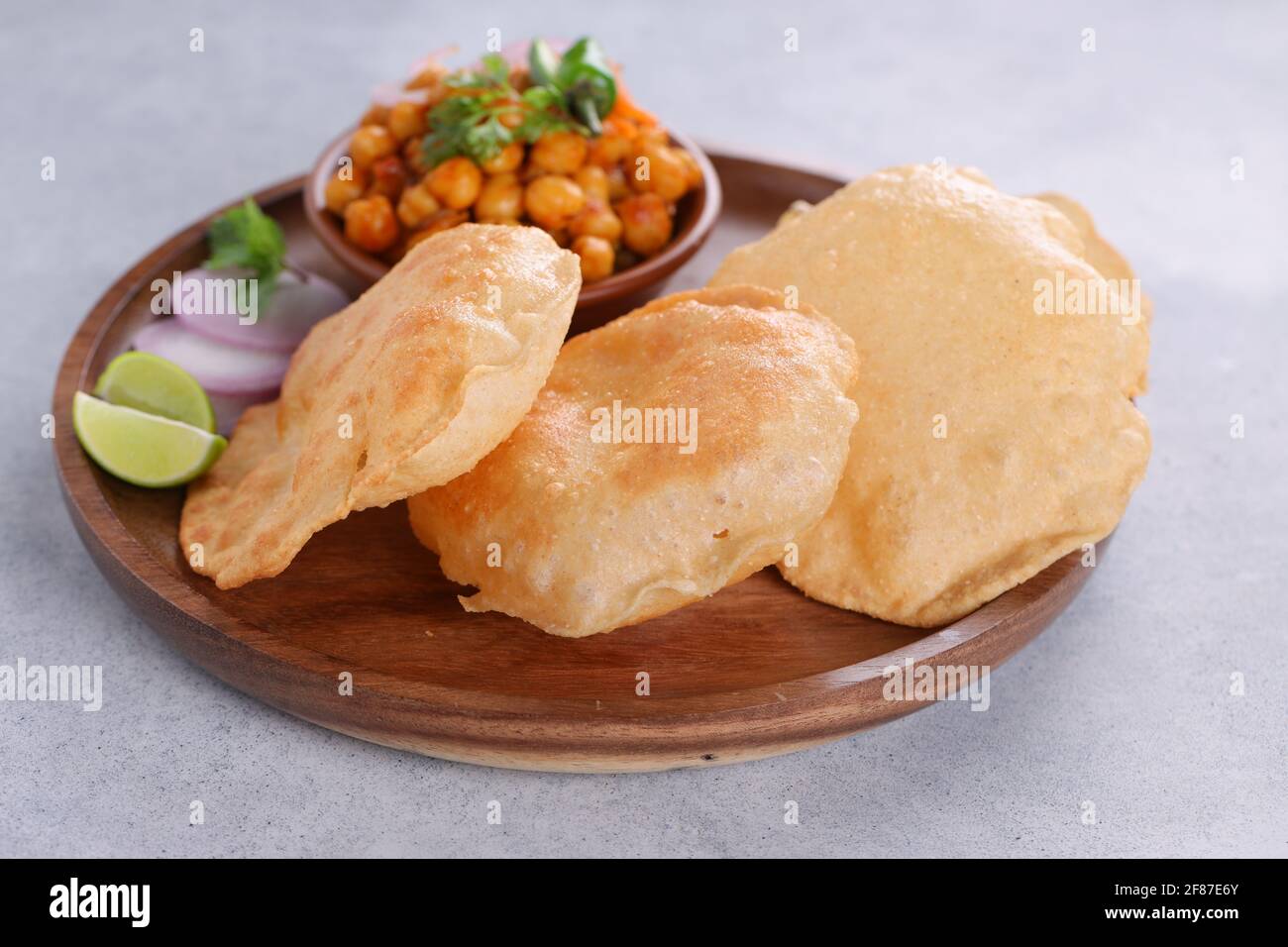 Indisches Frühstück  Puri mit Kichererbsenchana Masala-Puri, leckerem indischem Gericht Hergestellt aus Allzweck-Weizenmehl, das in angeordnet ist Eine Holzplatte mit Stockfoto