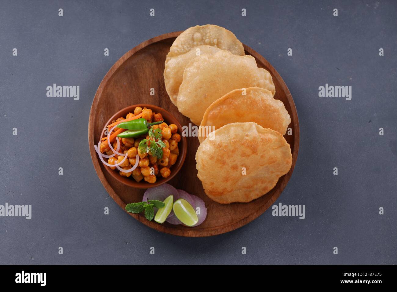 Indisches Frühstück  Poori mit Kichererbsenchana Masala, leckerem indischem Gericht Hergestellt aus Allzweck-Weizenmehl, das in angeordnet ist Eine Holzplatte mit Stockfoto