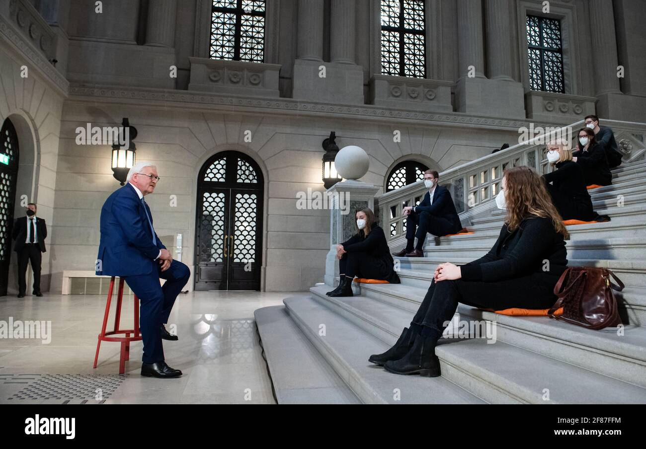 Berlin, Deutschland. April 2021. Bundespräsident Frank-Walter Steinmeier plaudert mit einigen Studenten im Treppenhaus der wiedereröffneten Staatsbibliothek Berlin nach seiner Rede vor den Studierenden der deutschen Hochschulen, die im Livestream verfolgt werden konnte. Zu Beginn des Sommersemesters will er unter anhaltenden pandemischen Bedingungen so viele Studierende wie möglich auf diese digitale Weise erreichen. Quelle: Bernd von Jutrczenka/dpa Pool/dpa/Alamy Live News Stockfoto