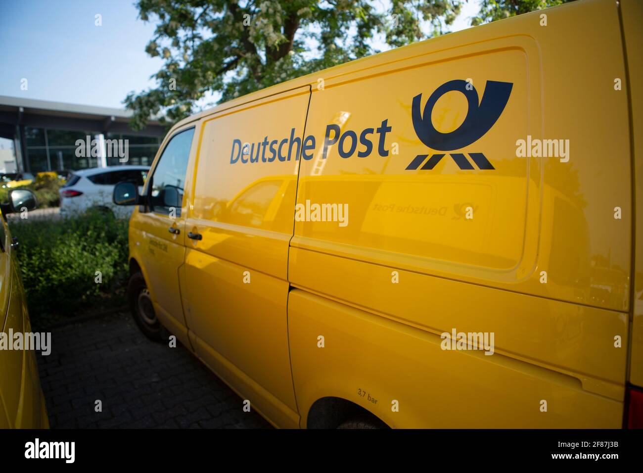 VW Bus der Deutschen Post in knalligem Gelb Stockfoto