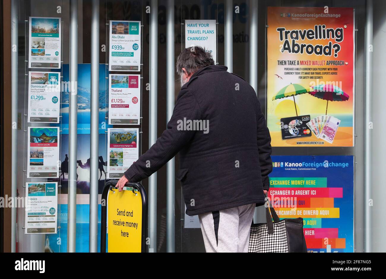 Southampton, Hampshire, Großbritannien. April 2021. Ein Mann schaut auf ein Reisebüro-Fenster, das ausländische Feiertage anwirbt, da nicht unbedingt erforderliche Geschäfte, einschließlich Reisebüros, in England wieder eröffnet werden dürfen, sind Überseeferien derzeit verboten. Credit Stuart Martin/Alamy Live News Stockfoto