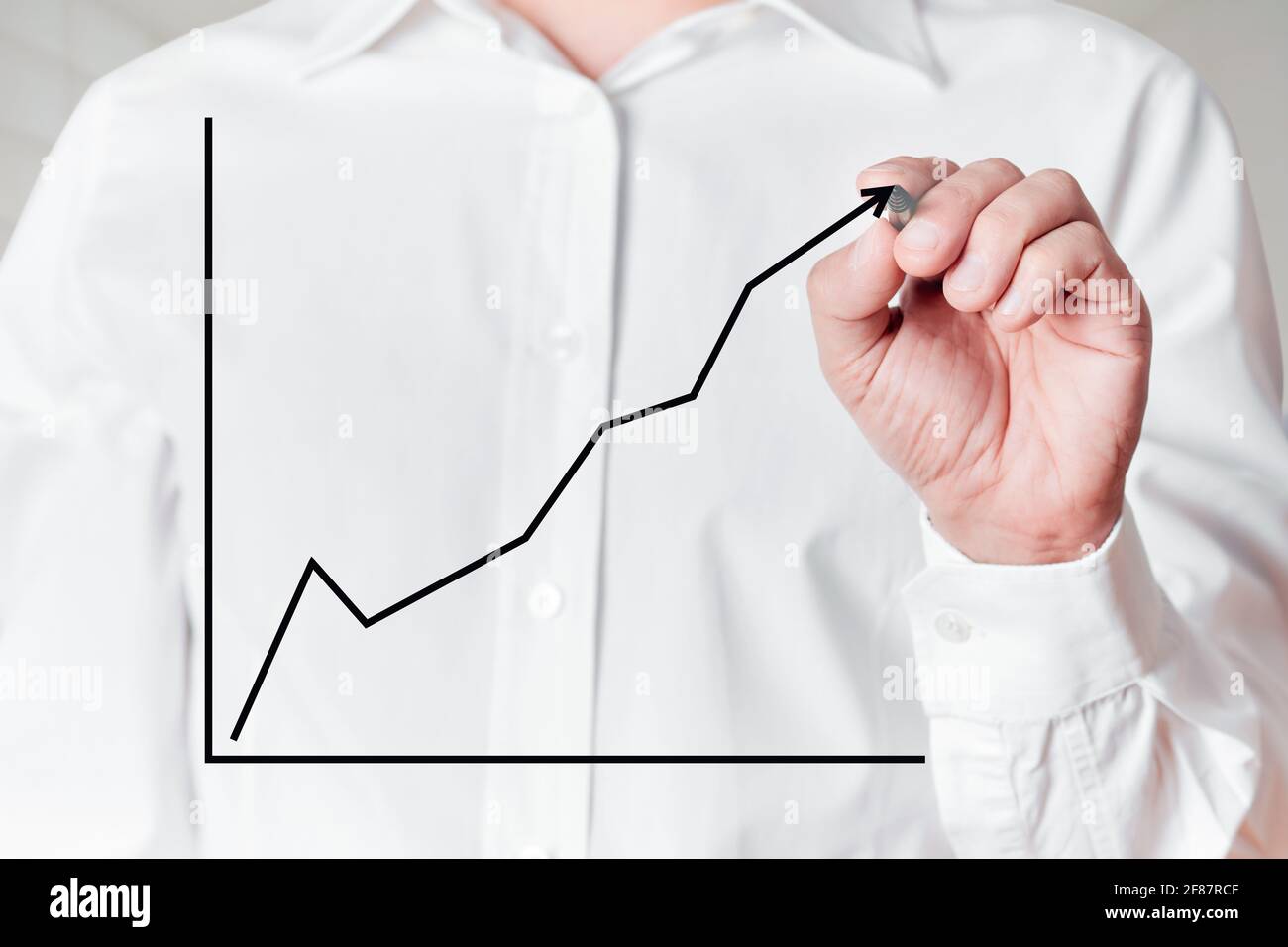 Geschäftsmann mit Stift zeichnet eine steigende Linie Diagramm auf einem virtuellen Bildschirm. Stockfoto