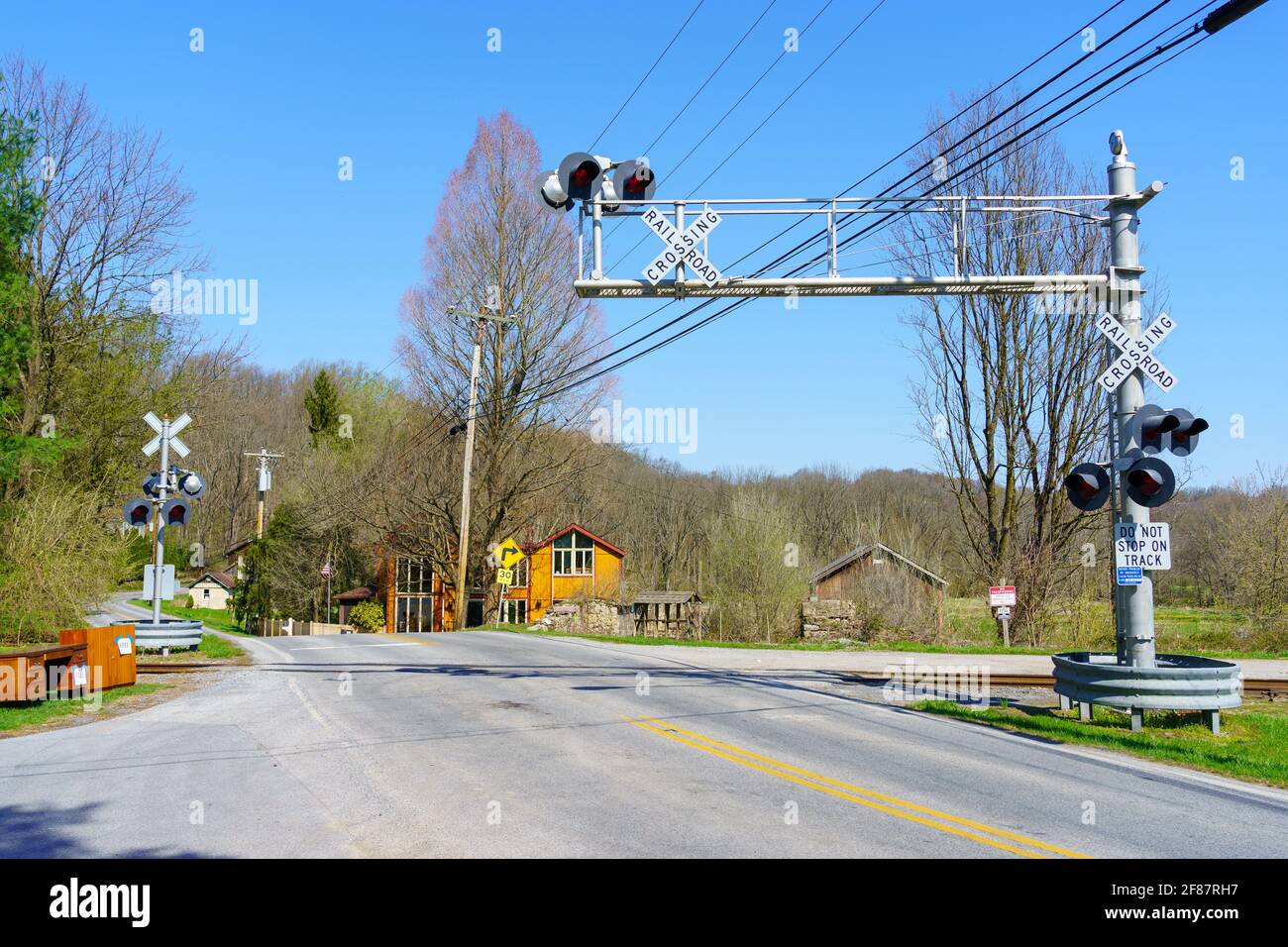 Embreeville, PA, USA - 6. April 2021: Ein Eisenbahnübergang mit elektrischen Überkopfwarnleuchten im ländlichen Chester County, PA. Stockfoto