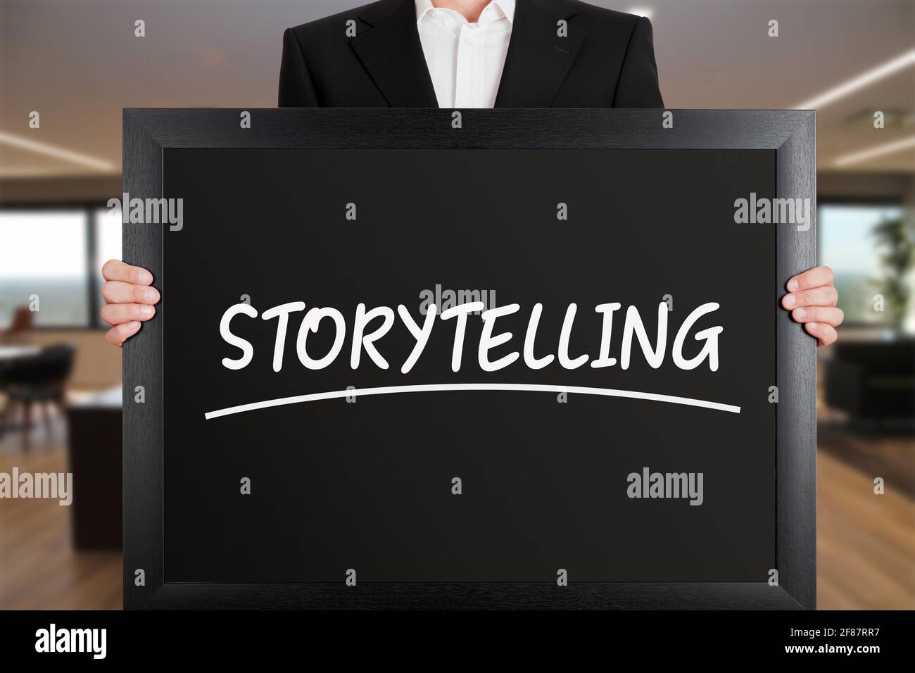 Geschäftsmann hält ein großes Schild mit der Botschaft Storytelling. Geschäftsmarketing-Konzept. Stockfoto