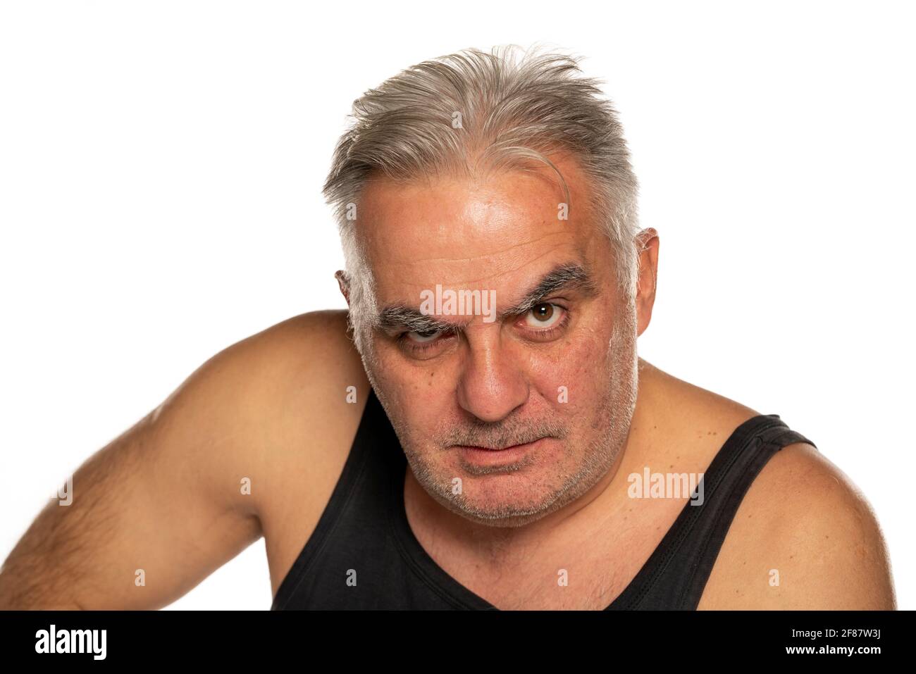 Wütender Mann mittleren Alters mit kurzen grauen Haaren auf Weiß Hintergrund Stockfoto