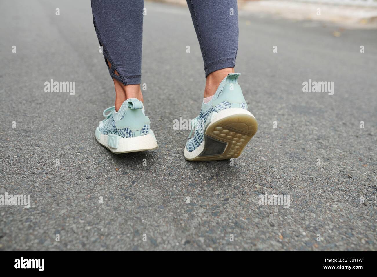 Füße der weiblichen Läuferin, die auf Asphalt im Freien joggen Der Morgen beim Training für den Marathon Stockfoto