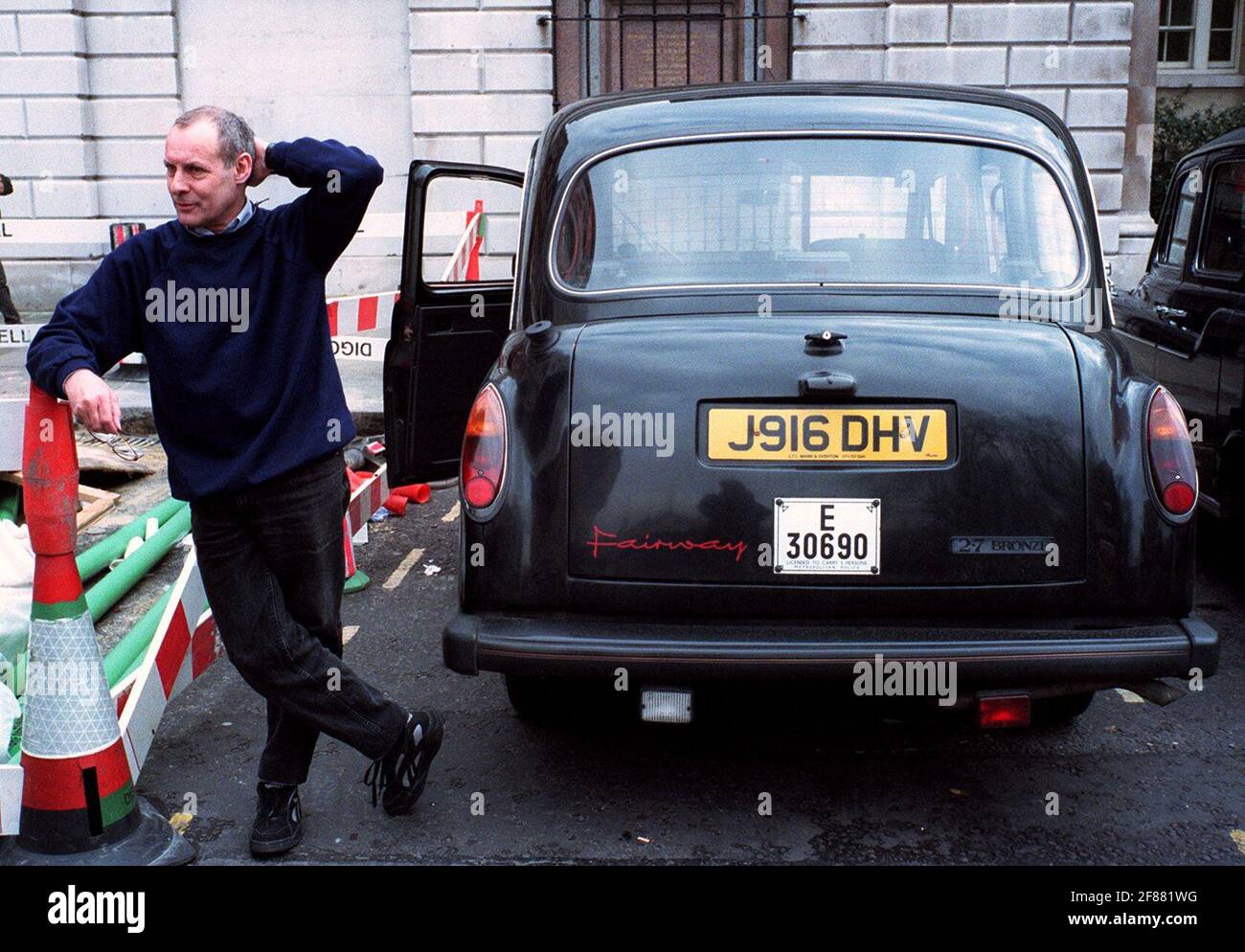 Aubrey Saffer London Taxifahrer März 1999.Cabbie steht neben seinem Schwarzes Taxi in Smithfield kratzt sich am Kopf Stockfoto