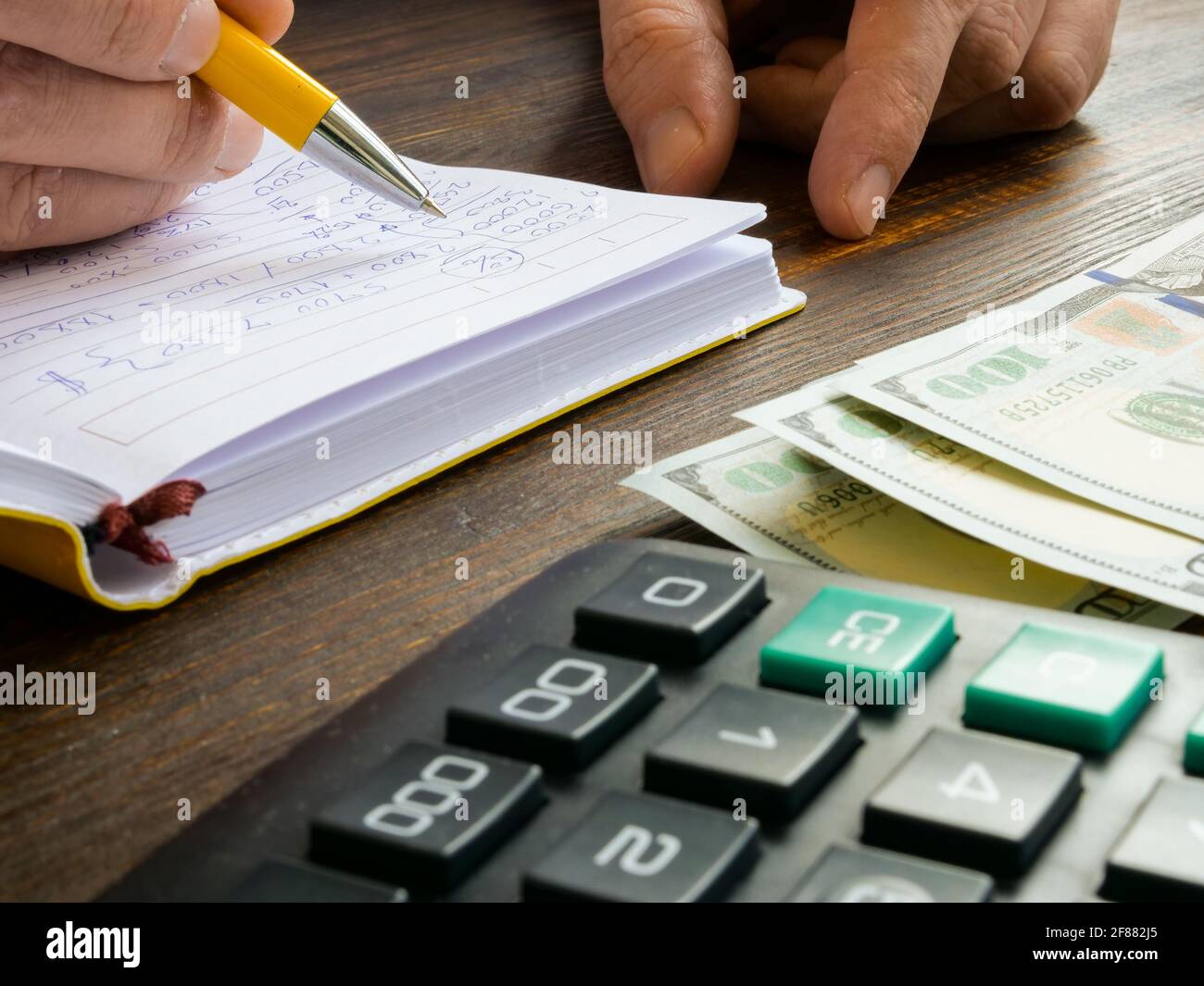 Ein Mann macht finanzielle Notizen und Buchhaltungseinträge für ein kleines Unternehmen. Stockfoto