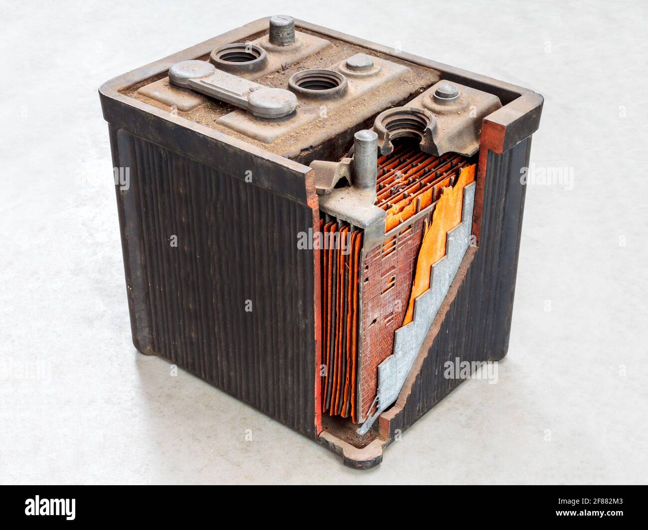 Alte Autobatterie mit teilweise geöffneter Karosserie auf einem Licht Grauer Hintergrund Stockfoto