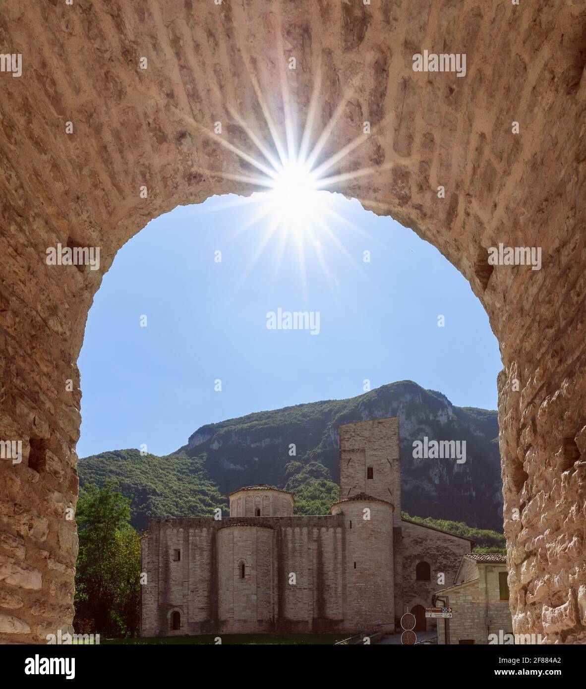 Ansicht der römisch-katholischen Abtei (San Vittore alle Chiuse) vom mittelalterlichen Bogen. Genga, Marken, Italien Stockfoto