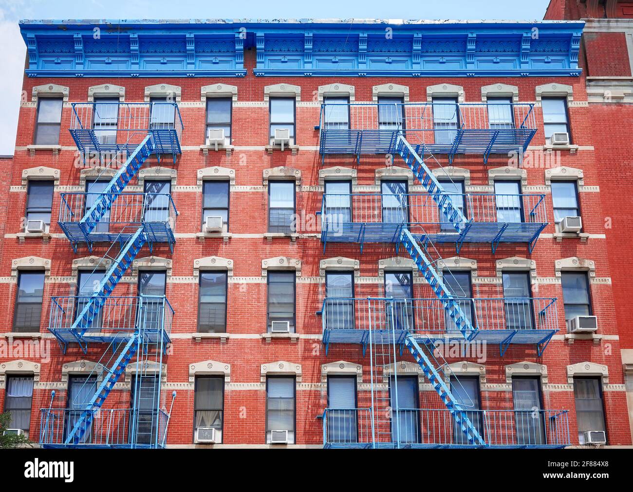 Altes rotes Ziegelgebäude mit blauen Eisenfeuerlöschern, New York City, USA. Stockfoto