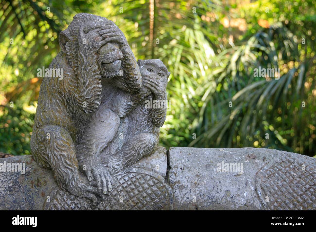 Geschnitzter Steinaffe mit Baby-Statue im Affentempel in Ubud, Bali, Indonesien Stockfoto