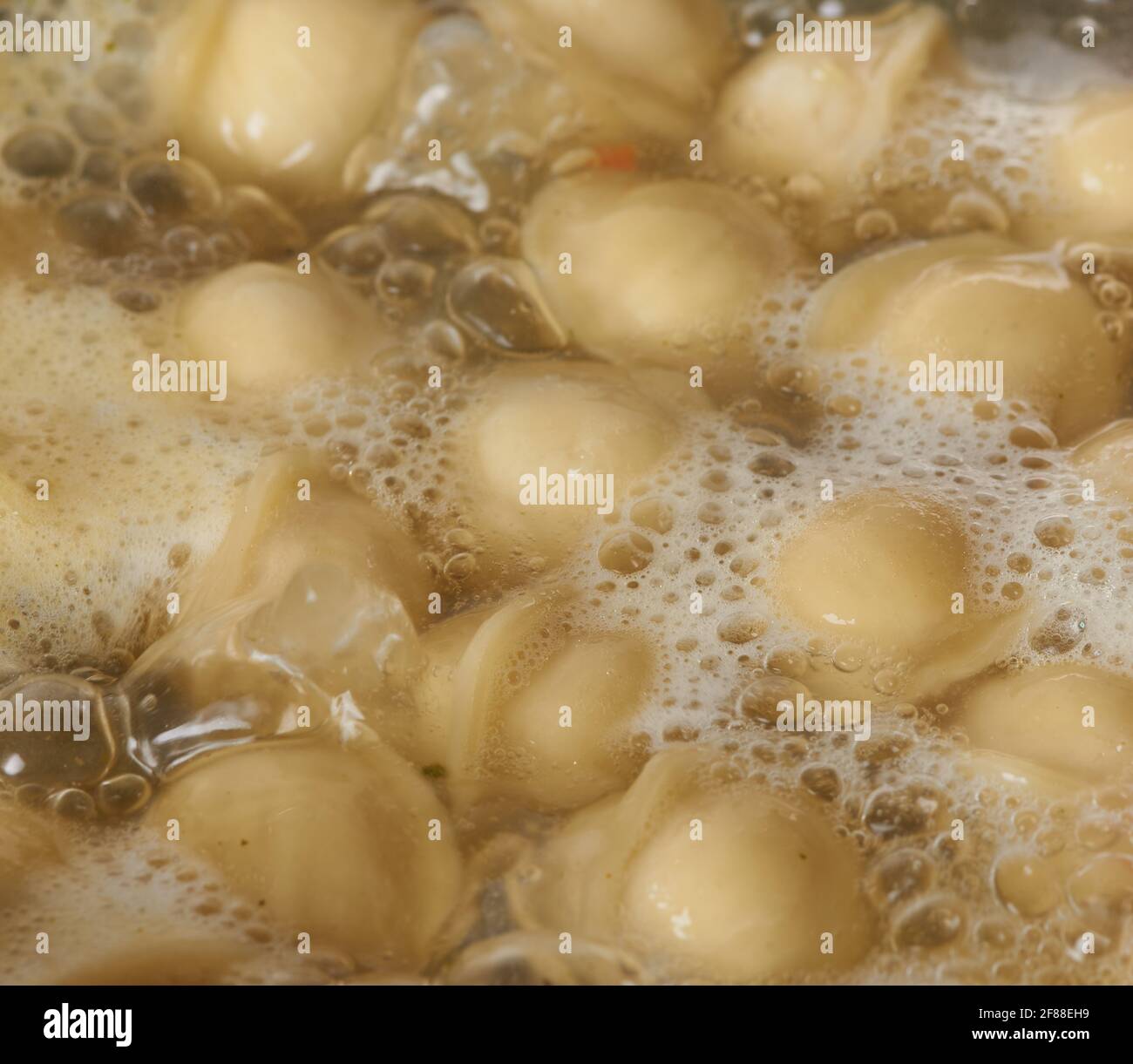 Köstliche Knödel werden in kochendem Wasser gekocht Stockfoto