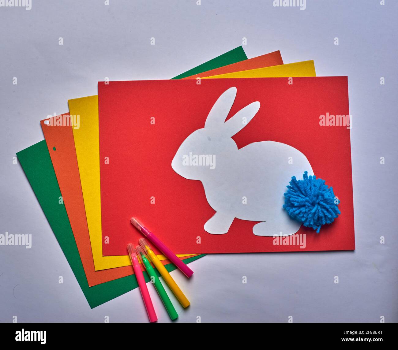 Farbiges Papier mit Filzstiften und Osterhase Stockfoto