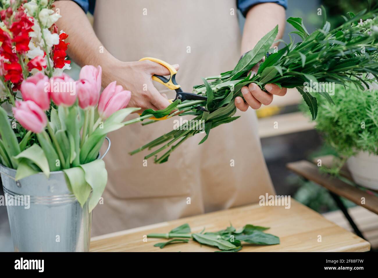 Mann Unternehmer in Schürze arbeiten an eigenen Blumengeschäft machen Blumenstrauß allein Stockfoto