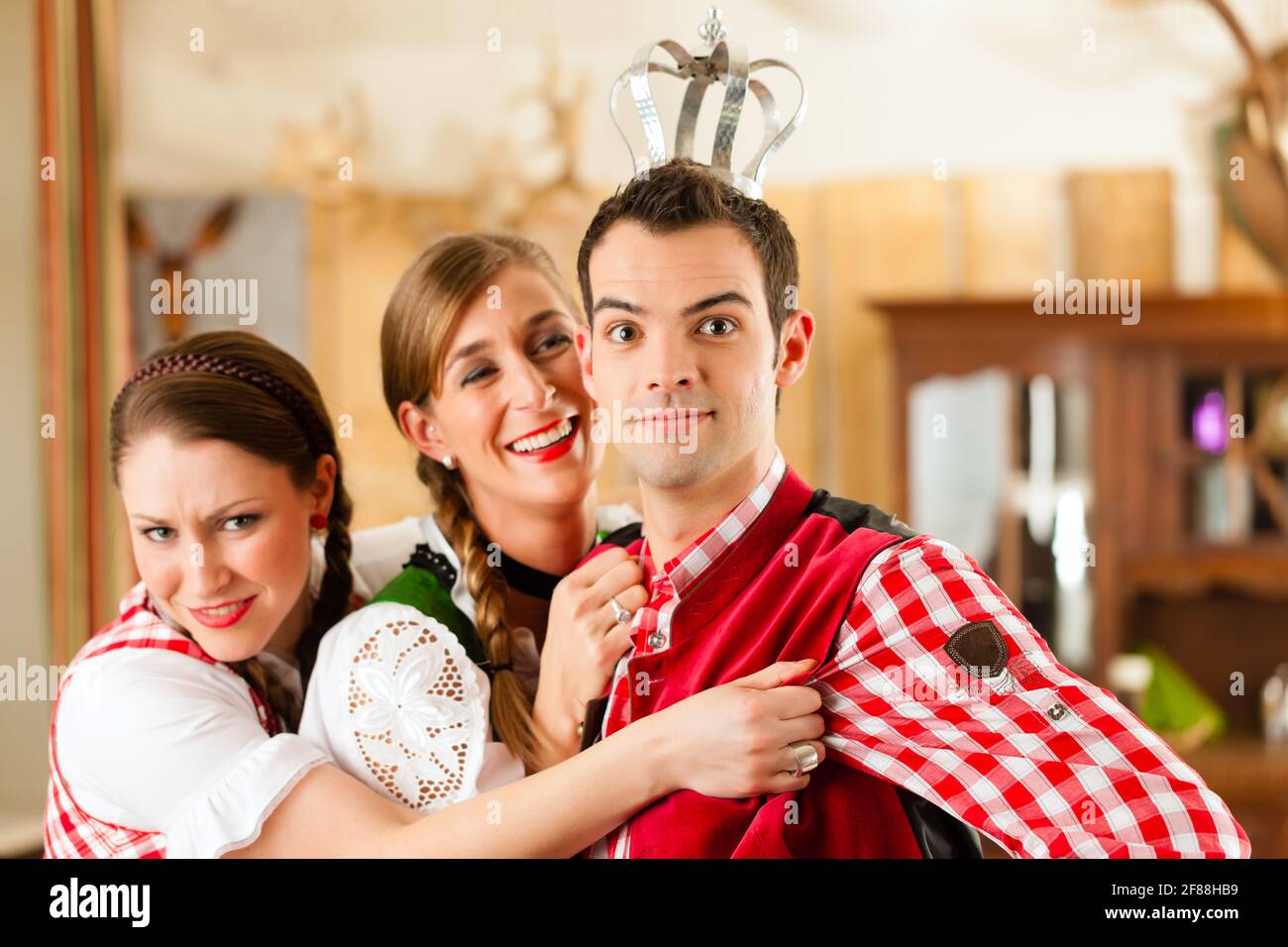 Junge Menschen in traditionellen bayerischen Tracht in Restaurant oder Pub Spaß und Witze Stockfoto