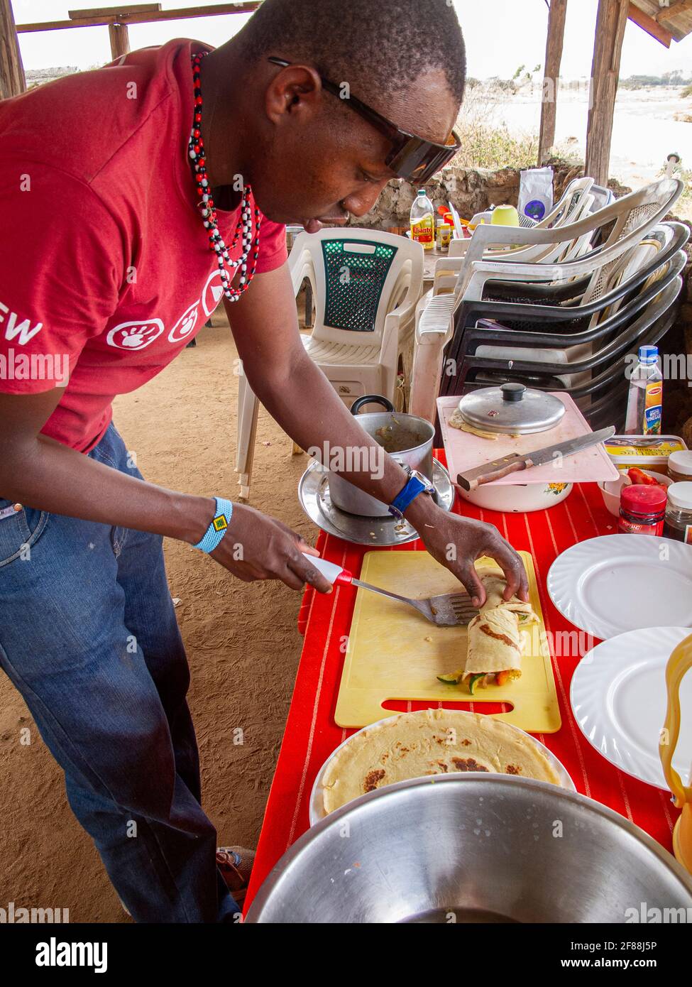Koch bereitet auf einer afrikanischen Safari ein Mittagessen für Touristen zu Stockfoto