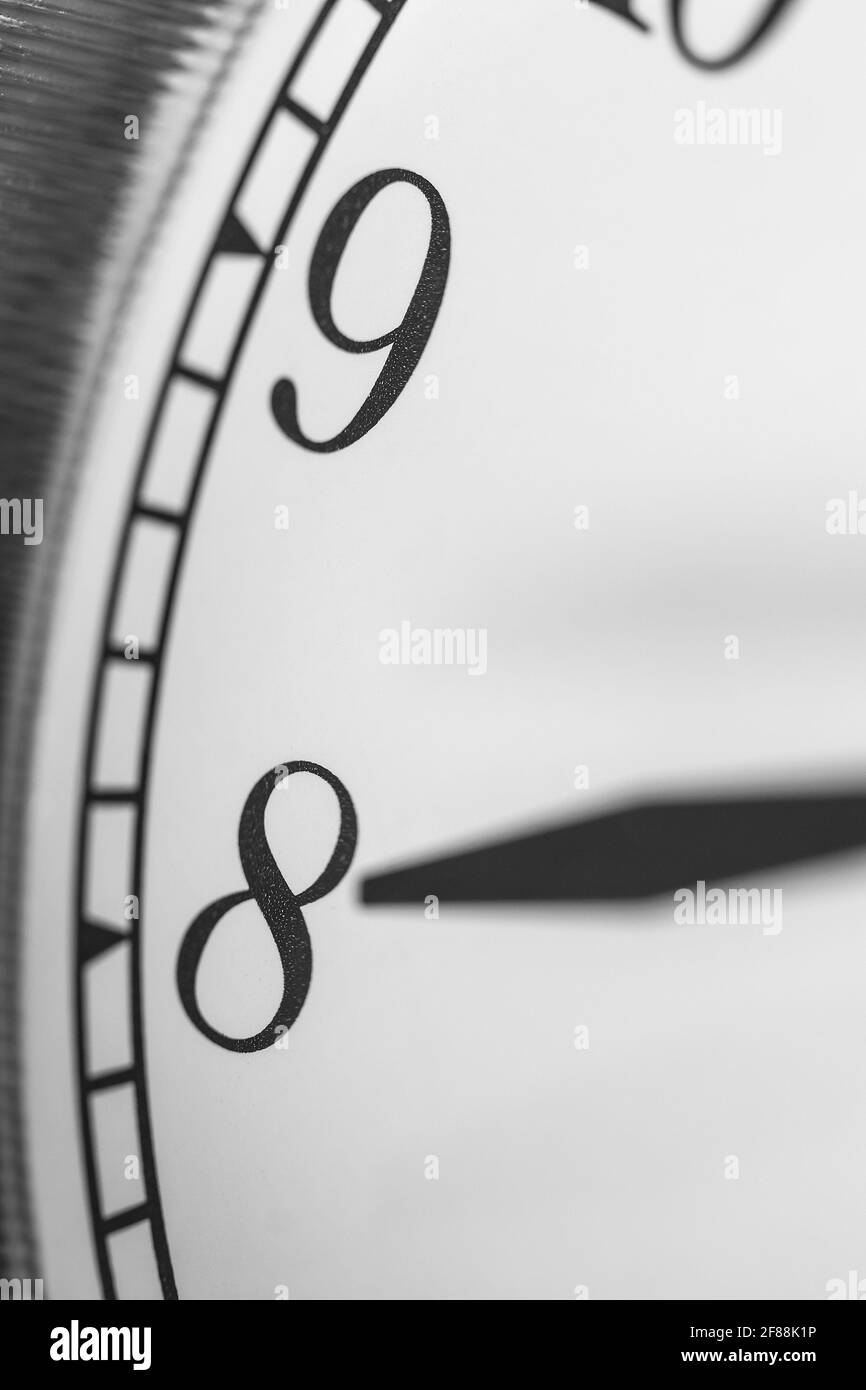 Uhrzeiger zeigt acht Uhr auf weißes Zifferblatt Klassischer Wecker mit zwei Glocken Stockfoto