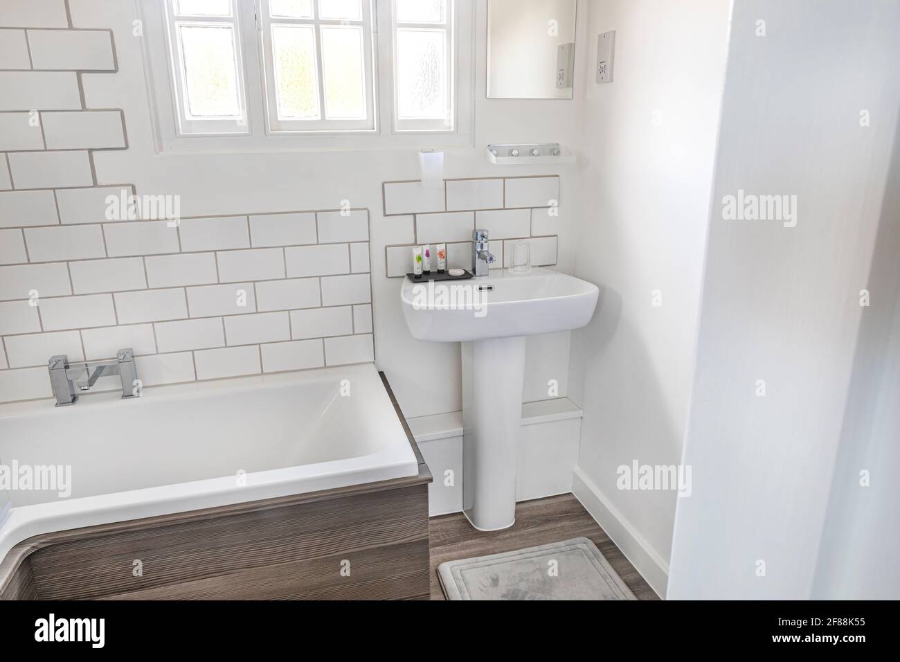 Ein modernes weißes Badezimmer mit Badewanne und Waschbecken Stockfoto