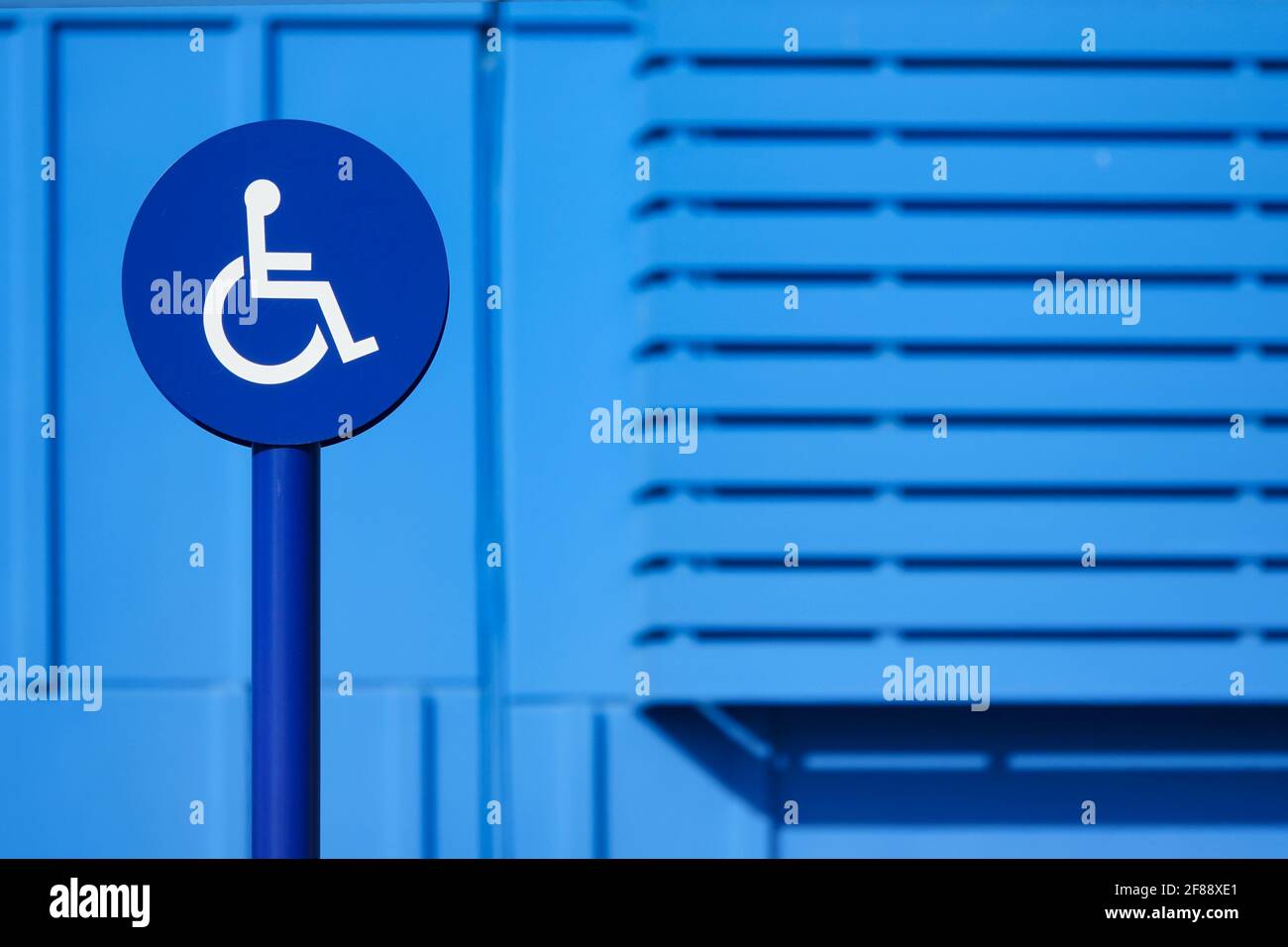 Rundes Vorzeichen für behinderte Menschen auf blauem Hintergrund Stockfoto