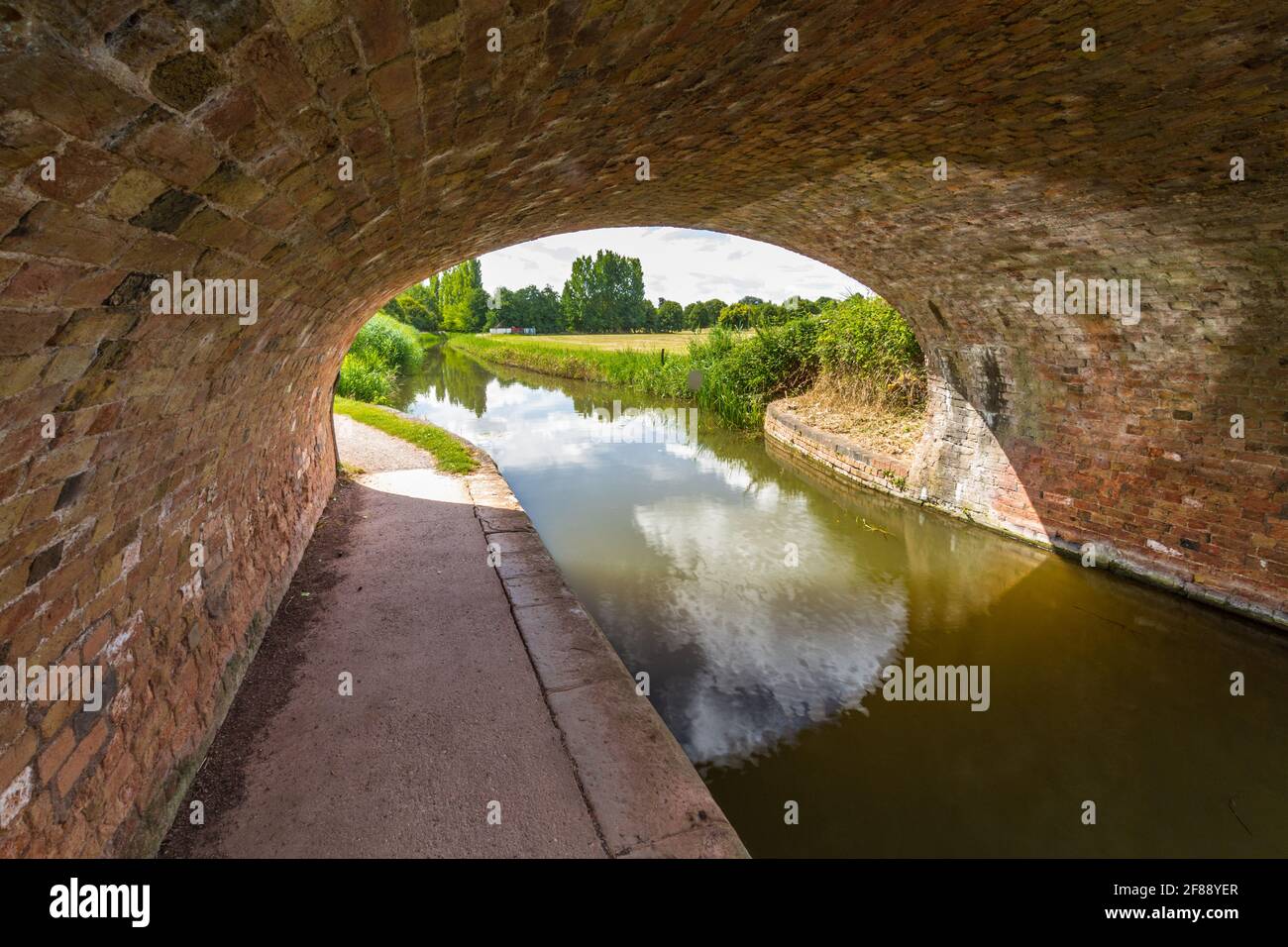 Treidelpfad unter der Brücke des British Canal an schönen sonnigen Sommertag. Taunton und Bridgewater Canal, Maunsel Lock, Großbritannien. Stockfoto