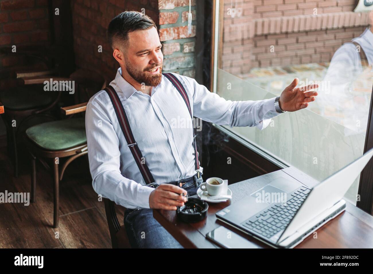 Junger Hipster Geschäftsmann mit einem Videoanruf in einem Café Stockfoto