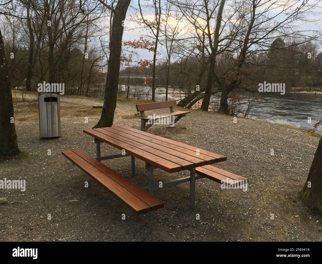 Leerer öffentlicher Picknickplatz mit Tisch, Bänken und Mülltonne für Müll im Spätwinter in der Nähe der Aare am Fluss in Brugg, Schweiz. Stockfoto