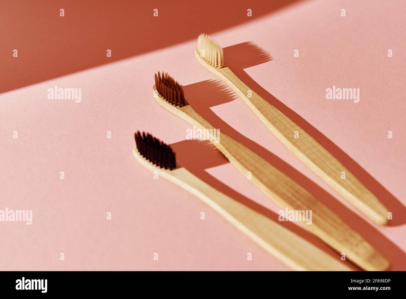 Umweltfreundliche Bambus-Zahnbürsten auf rosa Hintergrund. Flach liegend, Draufsicht. Stockfoto