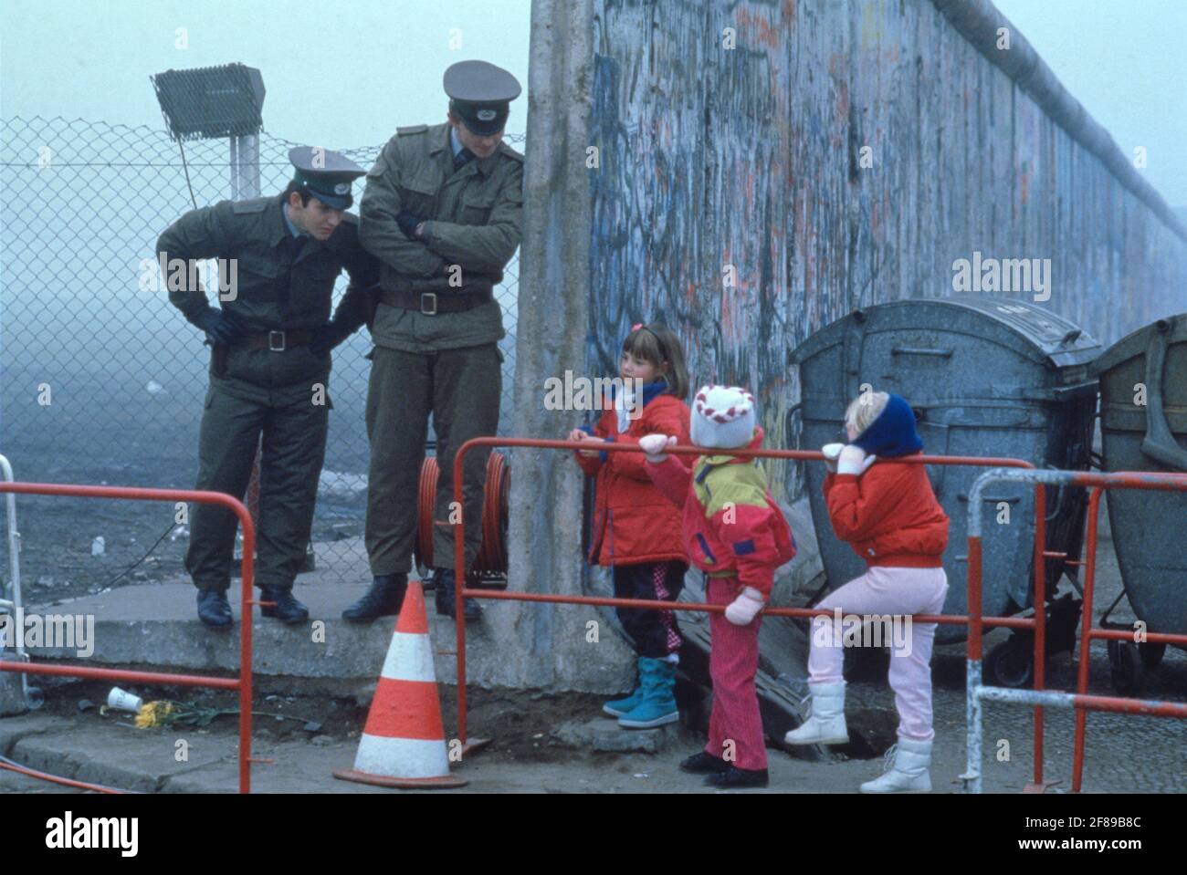 DDR-Wachen sprechen mit West-Berliner Kindern auf ihren Schulweg nach der Wiedervereinigung November 1989 Stockfoto
