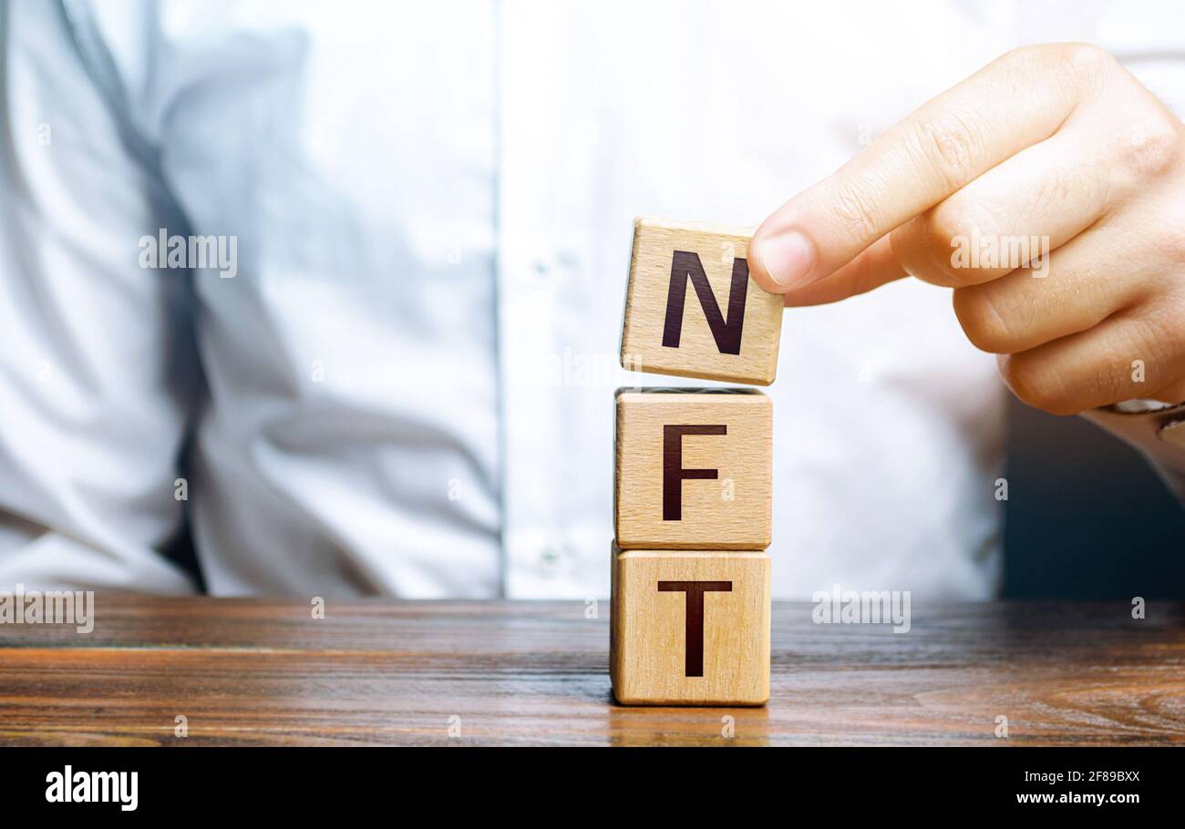 Man stellt Wort NFT aus Blöcken zusammen. Nicht fungibler NFT-Token. Verkauf von digitalen Kunstwerten über Internet-Auktionen. Blockchain-Technologie. Monetizat Stockfoto