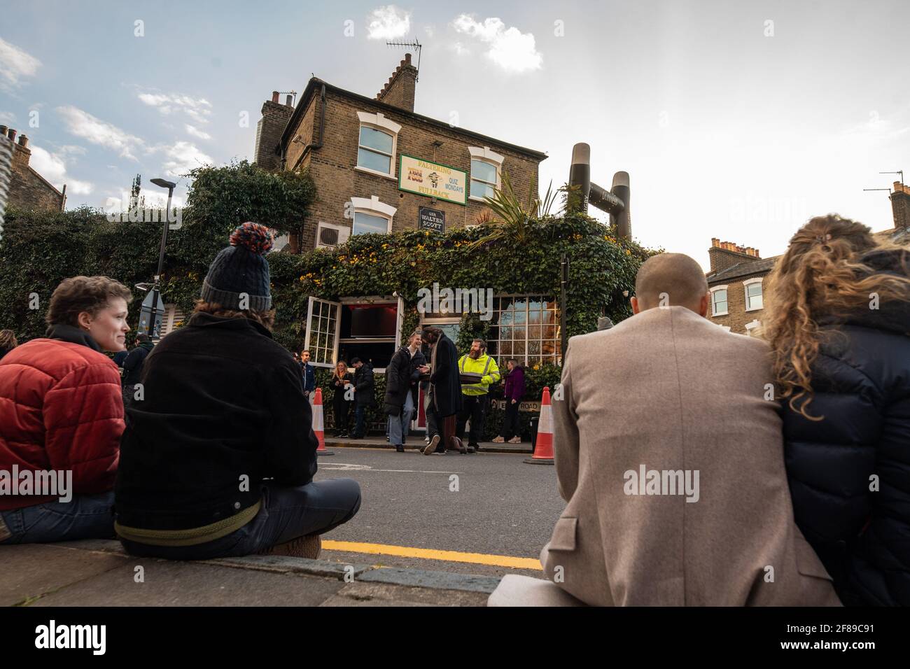 London, Großbritannien. 12. April 2021. Trinker vor dem stoppenden Fullback Pub im Finsbury Park, North London, das heute wieder für das Trinken von draußen geöffnet wurde, da die Lockdown-Maßnahmen in ganz Großbritannien gelockert werden. Bilddatum: Montag, 12. April 2021. Bildnachweis sollte lauten: Matt Crossick/Empics/Alamy Live News Stockfoto