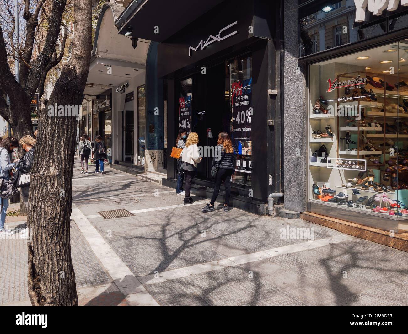 Thessaloniki, Griechenland - April 12 2021: Klicken Sie auf und sammeln Sie den offenen Ladeneingang mit wartenden Kunden. Schaufensterpräsentation von Ladenverkäufen mit einer Click-Away-Option aufgrund von covid-19-Sicherheitsvorkehrungen. Stockfoto
