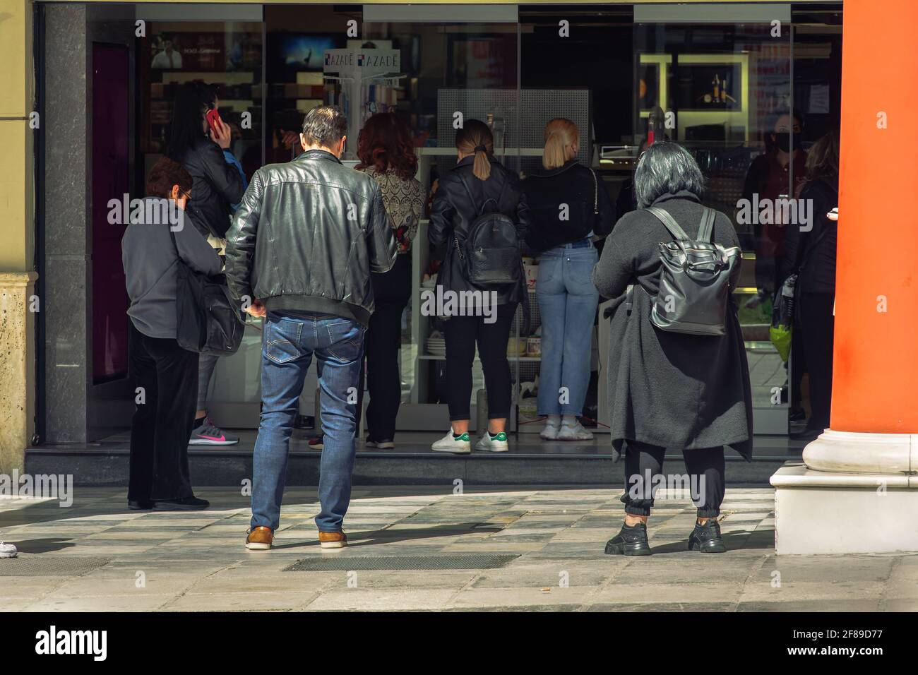 Thessaloniki, Griechenland - April 12 2021: Klicken Sie auf und sammeln Sie den offenen Ladeneingang mit wartenden Kunden. Schaufensterpräsentation von Ladenverkäufen mit einer Click-Away-Option aufgrund von covid-19-Sicherheitsvorkehrungen. Stockfoto