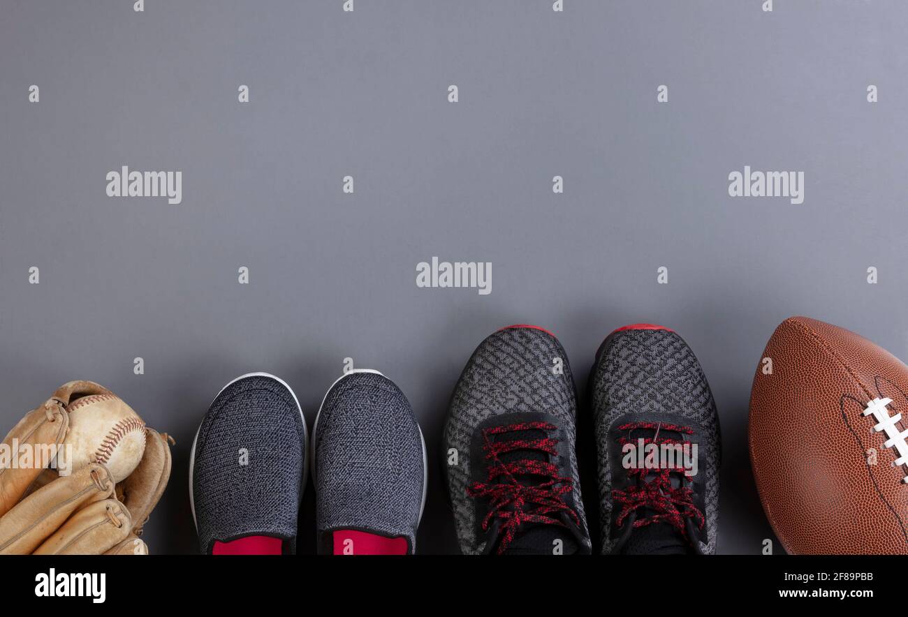 Väter Tag Konzept mit erwachsenen Männern und Kinder Schuhe und Sportballausrüstung auf grauem Hintergrund im flachen Lay-Format Stockfoto