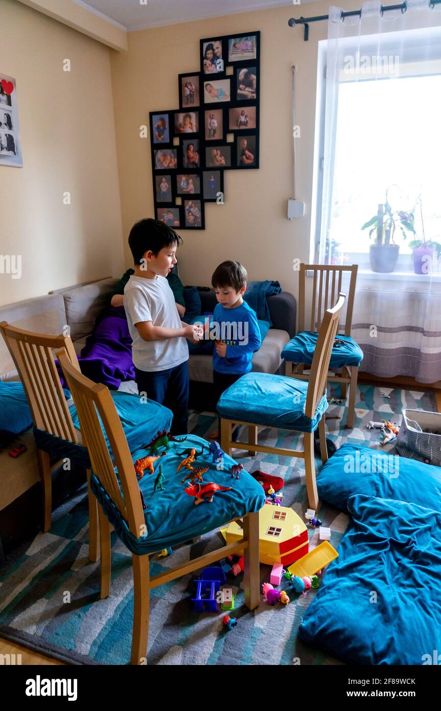 POSEN, POLEN - 10. Apr 2021: Zwei junge polnisch-kaukasische Jungen und  eine Frau in einem Wohnzimmer. Spielzeug und Holzstühle liegen herum  Stockfotografie - Alamy